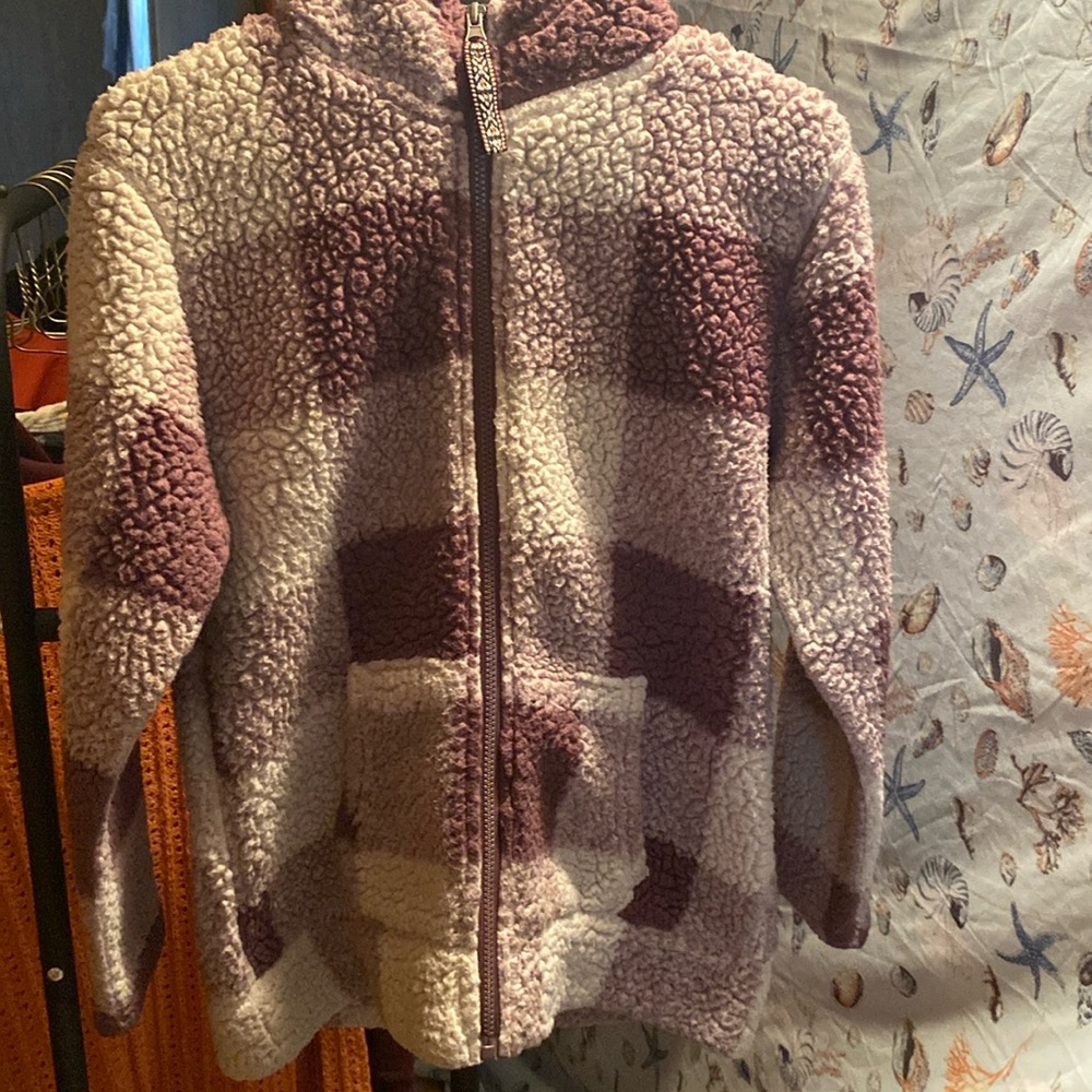 A women’s fuzzy zip up hooded sweatshirt. It’s purple and white checkered.